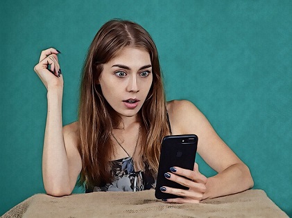 girl shocked holding phone